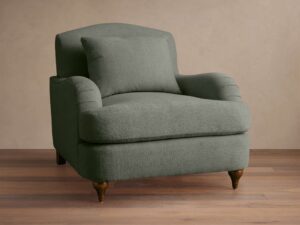 Ormau traditional sage green fabric club chair with a matching lumbar pillow and turned wooden legs.